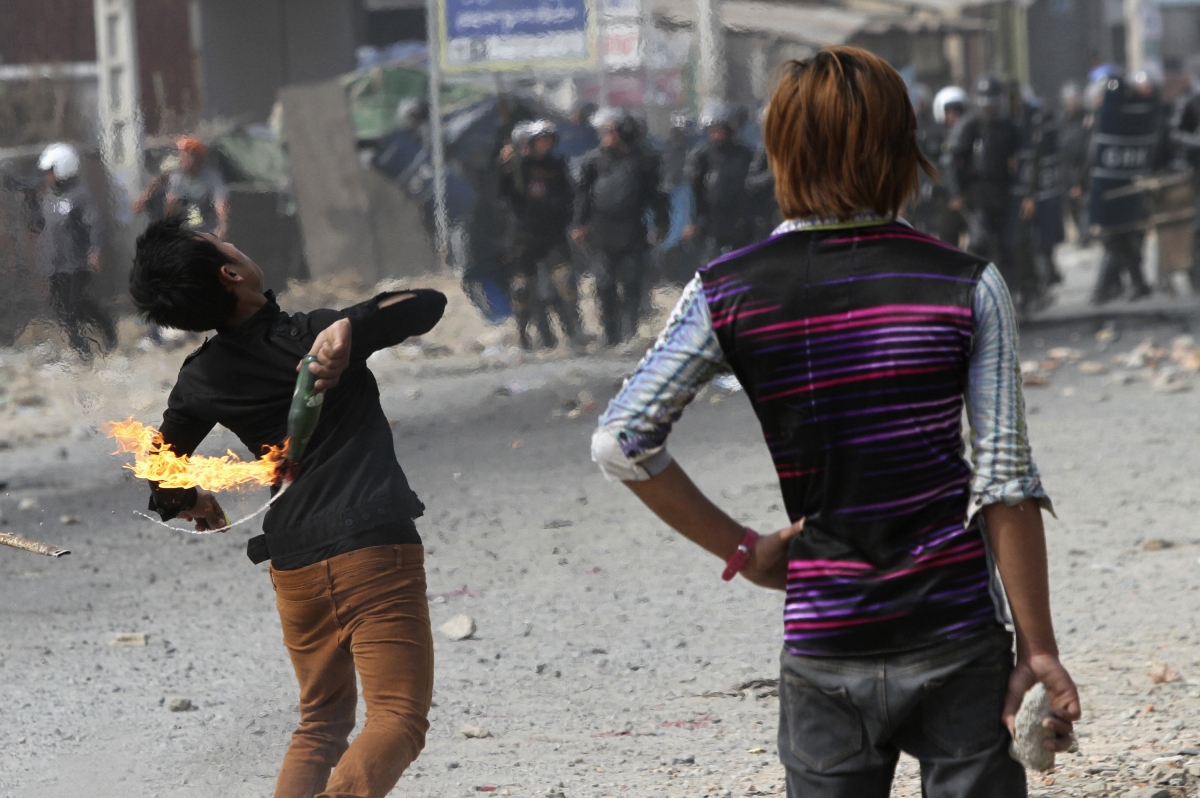 A worker throws a petrol bomb after clashes broke out during a protest in Phnom Penh Garment workers Phnom Penh