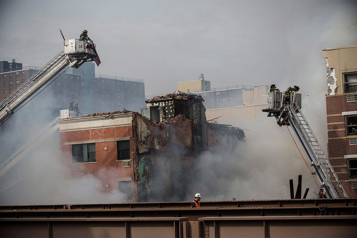 Firefighters work at the site of the collapsed building in the Harlem neighbourhood of Manhattan