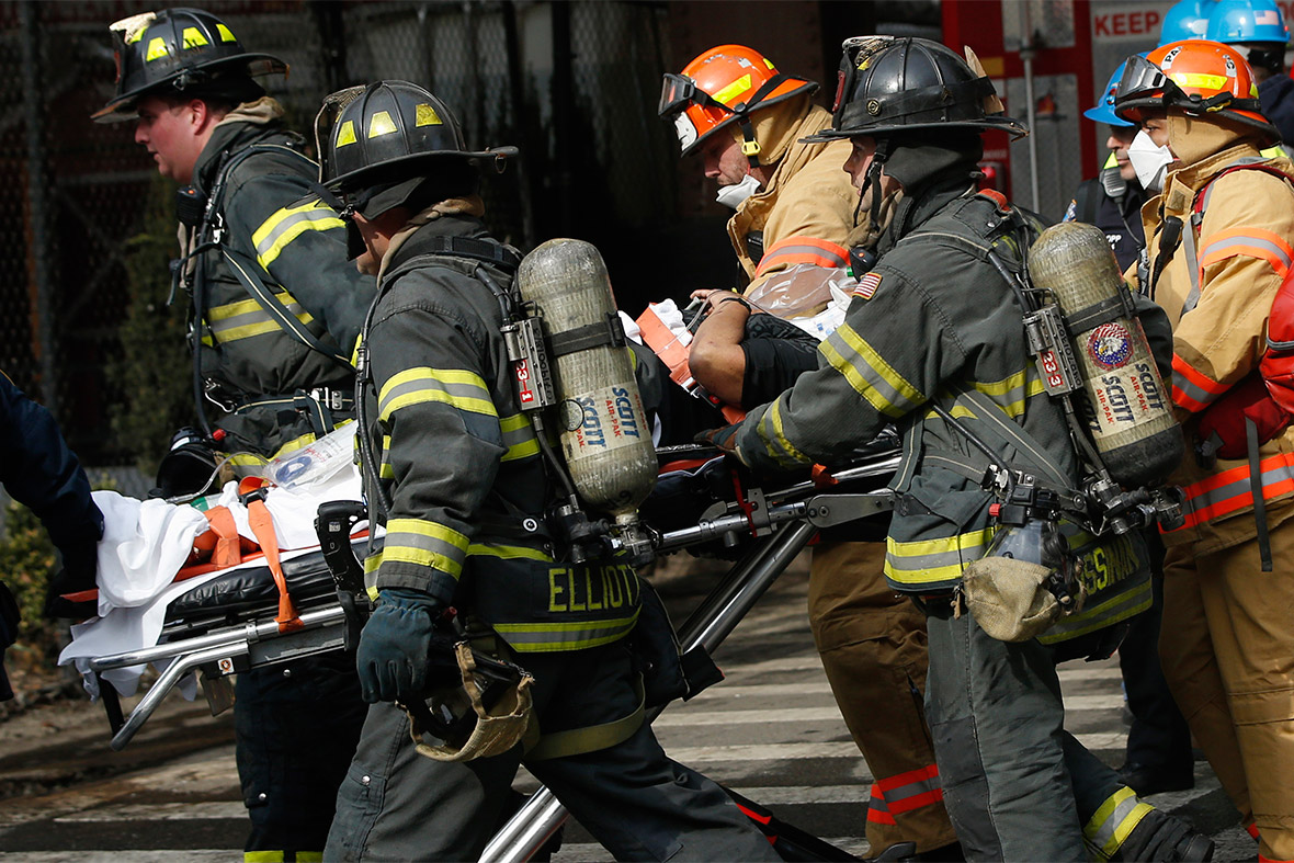 An injured man is evacuated by emergency personnel