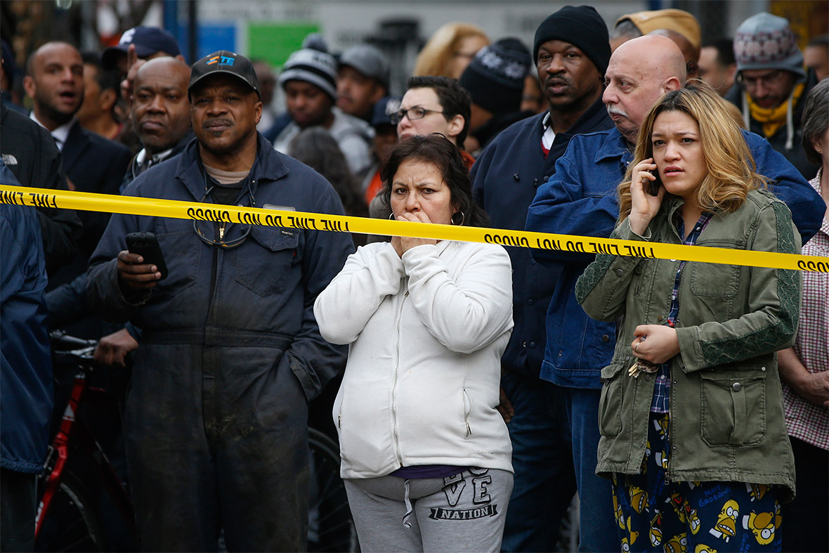 Residents watch emergency personnel work at the site of the collapse in Harlem