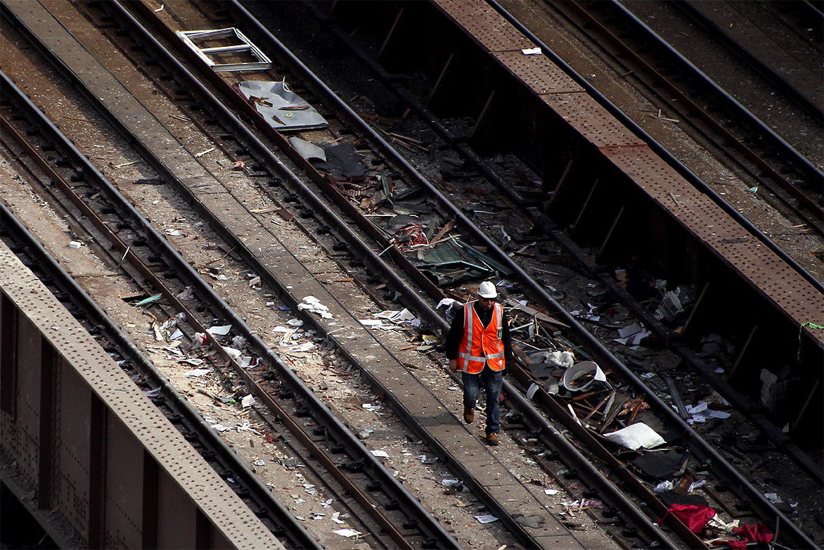 A worker walks along the Metro-North tracks strewn with debris from the explosion