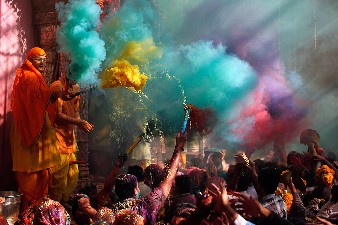 Hindu priests throws coloured powder on devotees during Holi celebrations at Bankey Bihari temple in Vrindavan, in the northern Indian state of Uttar Pradesh