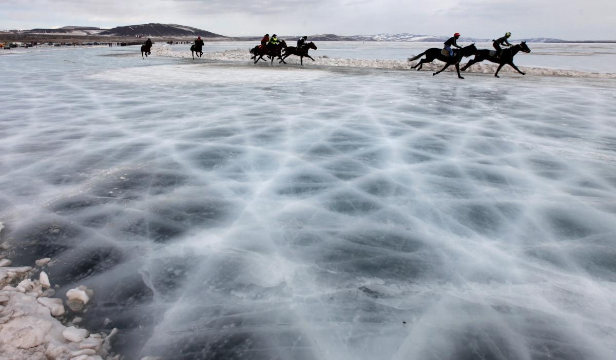 Riders compete on the frozen Yenisei River during the 44th Ice Derby amateur horse race near the settlement of Novosyolovo, some 250 km (155 miles) south of the Siberian city of Krasnoyarsk, 15 March 2014. The Ice Derby has been held in Novosyolovo annually since 1969 Yenisei River