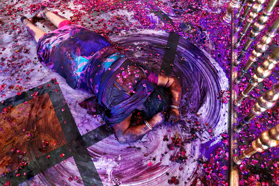 A Hindu woman prays while lying on the floor of a temple during Holi celebrations in the western Indian city of Ahmedabad