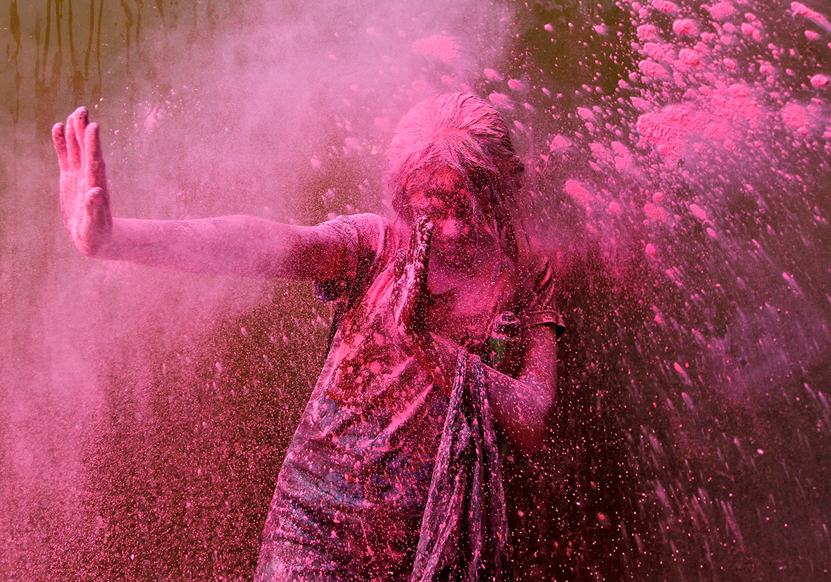A girl reacts as a friend throws coloured powder at her in Chennai