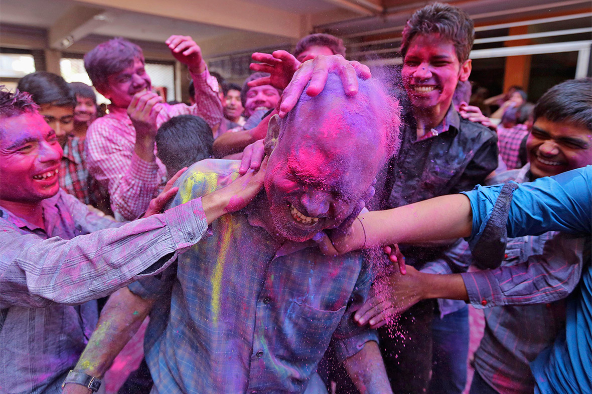 Students cover their teacher in coloured powders at a school in Ahmedabad