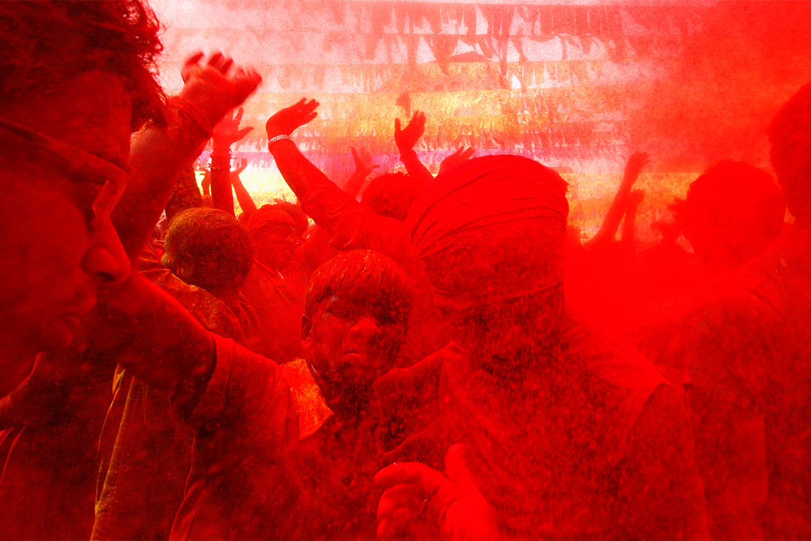 People daubed in colours dance as they celebrate Holi in the northeastern Indian city of Guwahati