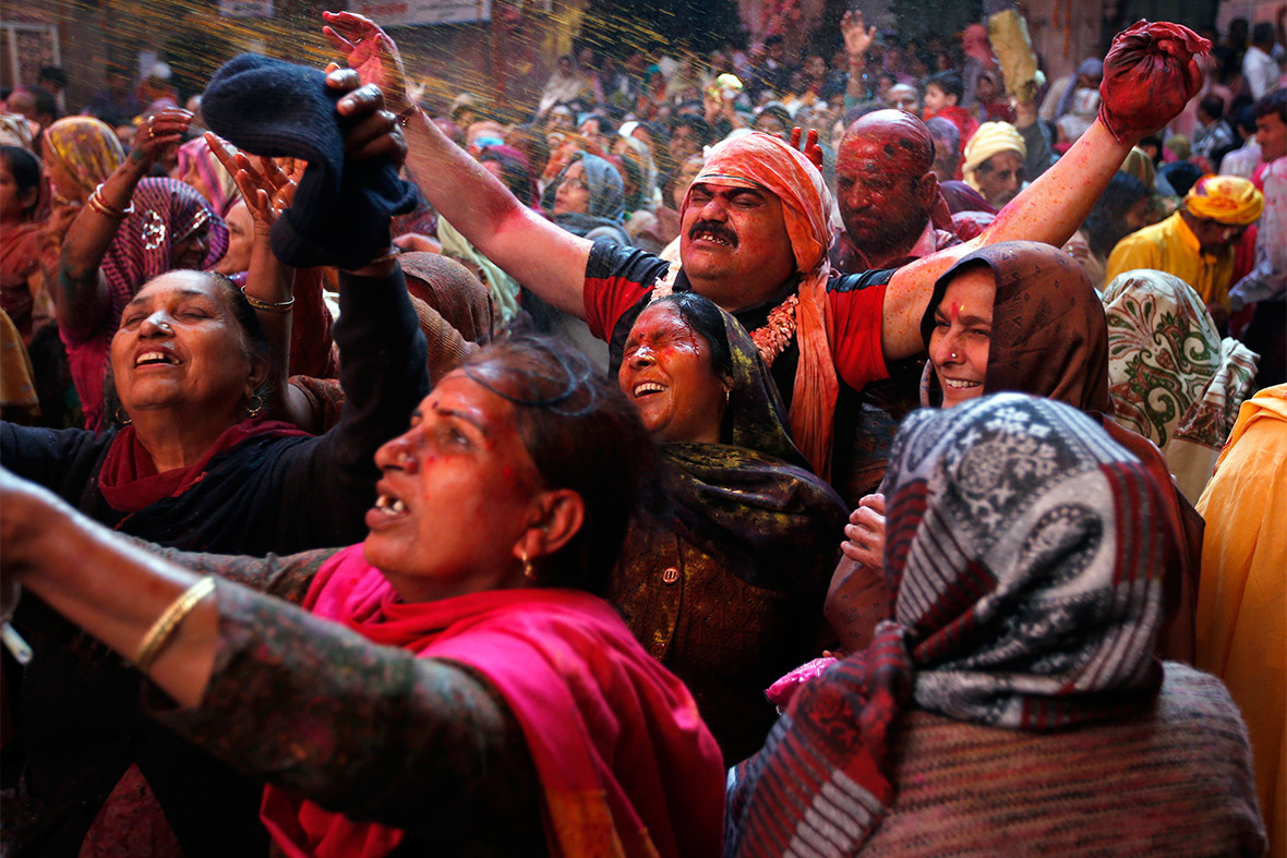 Hindu devotees react as they are sprayed with coloured water at Bankey Bihari temple