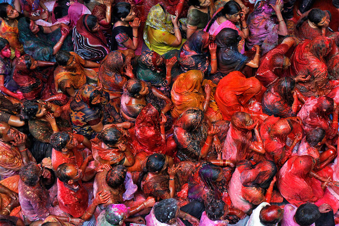 Devotees are soaked with coloured water as they sit singing hymns during Holi celebrations at Shamlal Ji temple in Kolkata