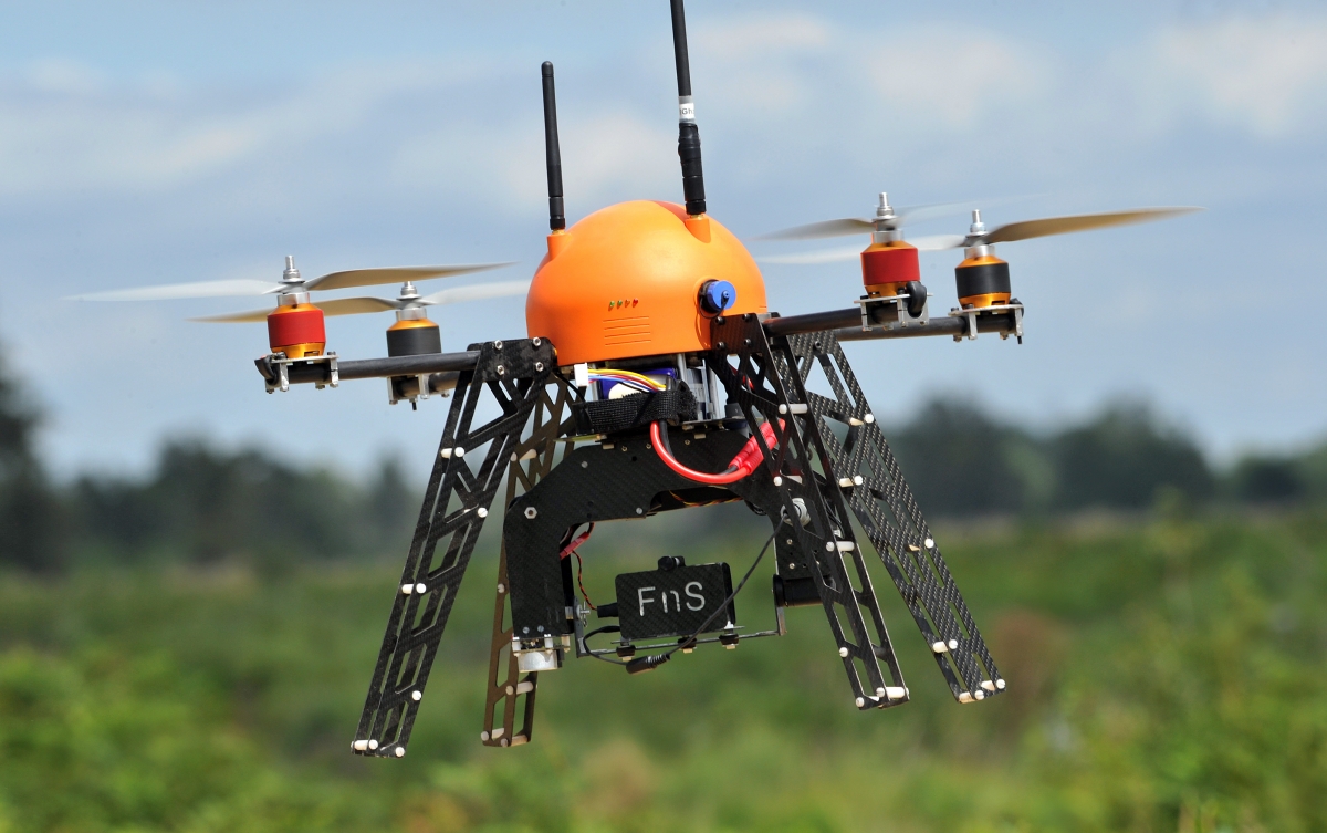 Unmanned flying drone flies across a farm