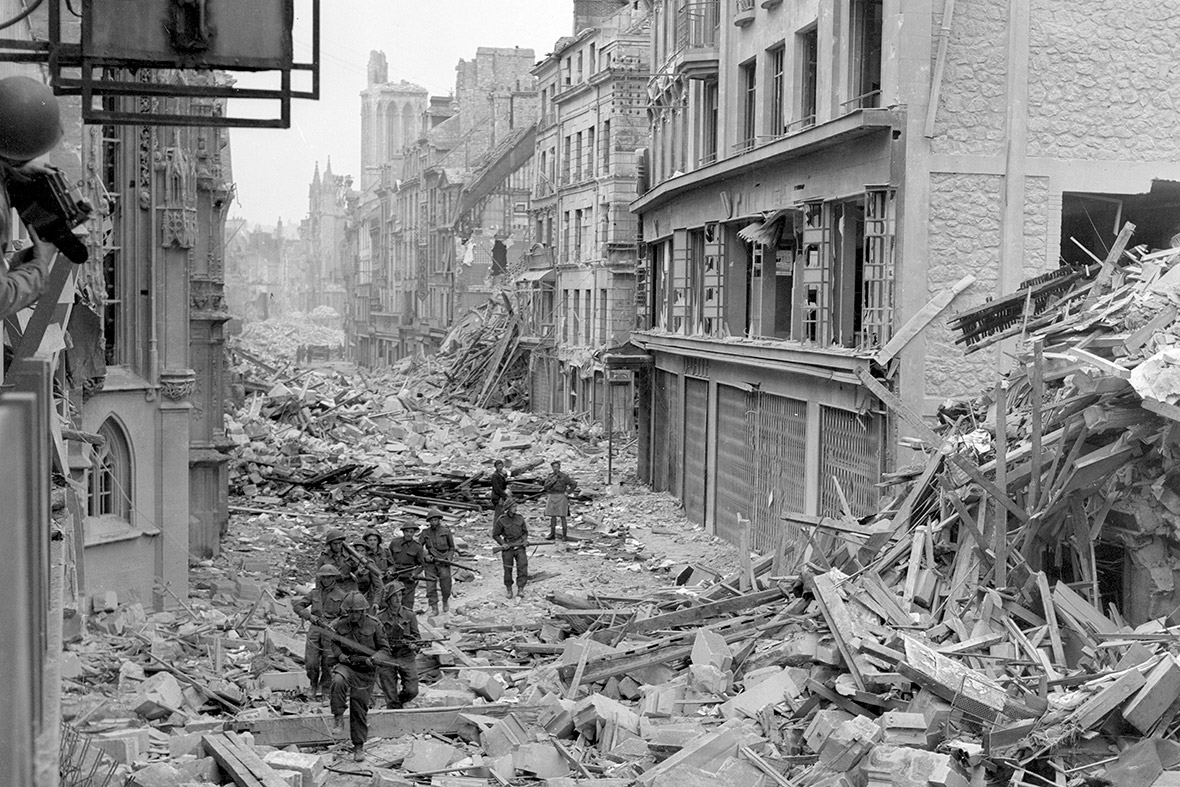 July 1944: Canadian troops patrol along the destroyed Rue Saint-Pierre after German forces were dislodged from Caen