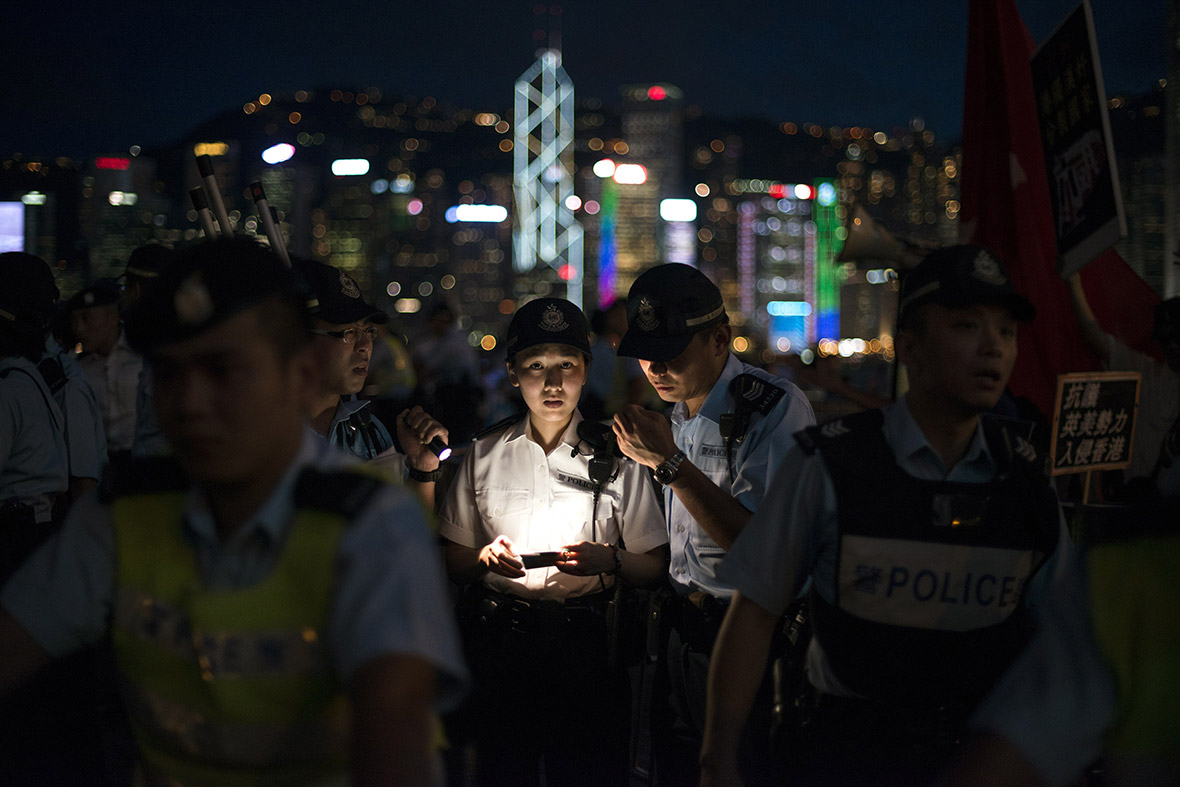 Hong Kong police officers discuss crowd control tactics as pro-democracy activists confront a pro-China group