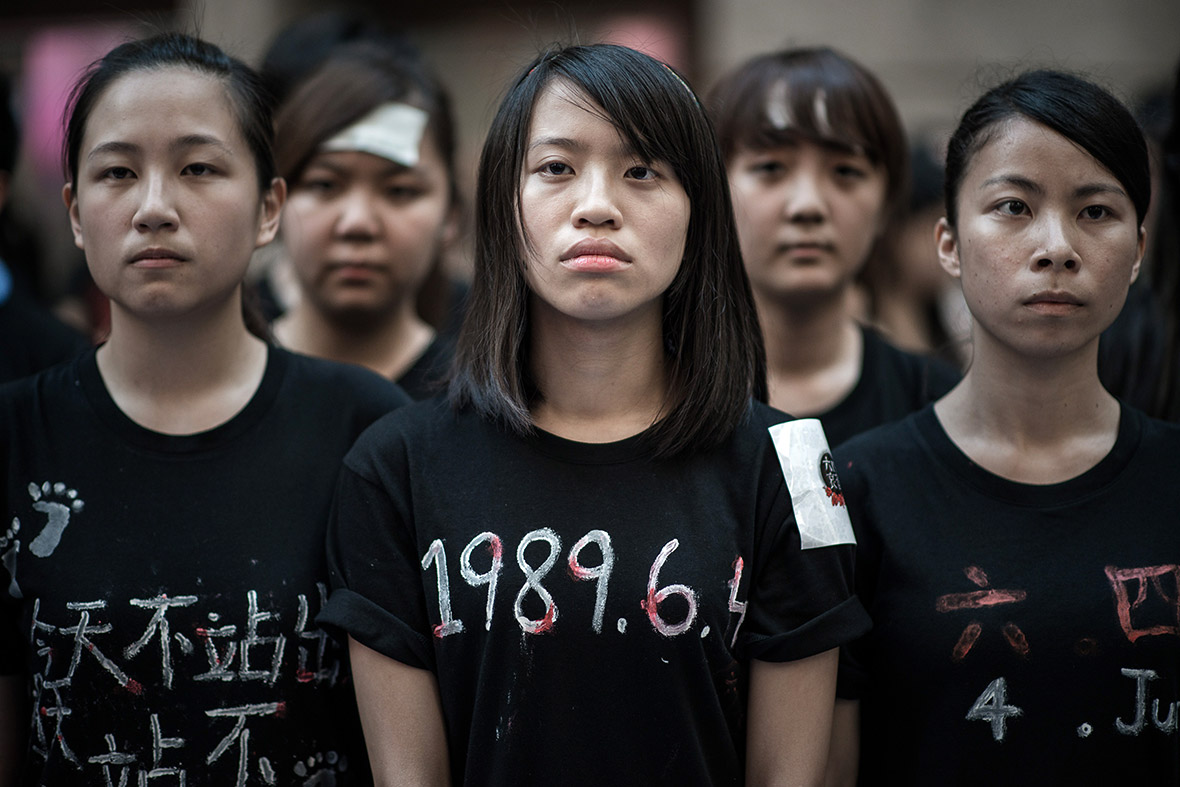 A student wearing a T-shirt with the date of the massacre written on it prepares to sing to commemorate the anniversary