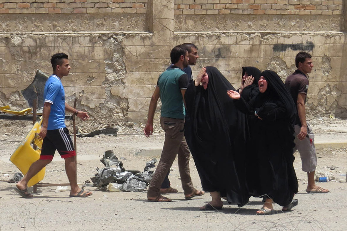 Women react at the site of a car bomb attack in the town of Tuz Khurmato, north of the capital Baghdad, Iraq.
