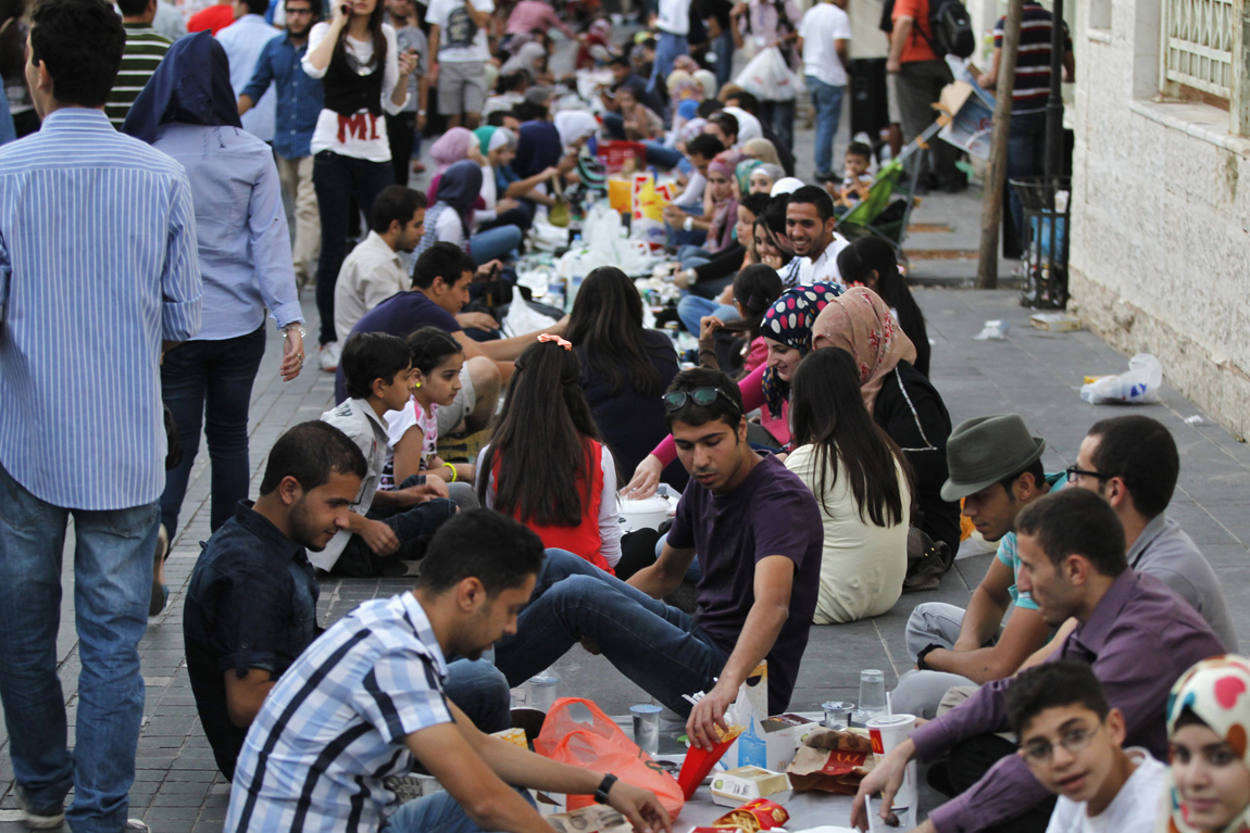 Hundreds gather on a street to break their fast together in Amman after being contacted through social media