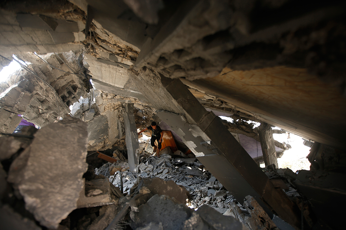 A Palestinian walks through the rubble of a house that was destroyed in an Israeli air strike, in the northern Gaza StripReuters