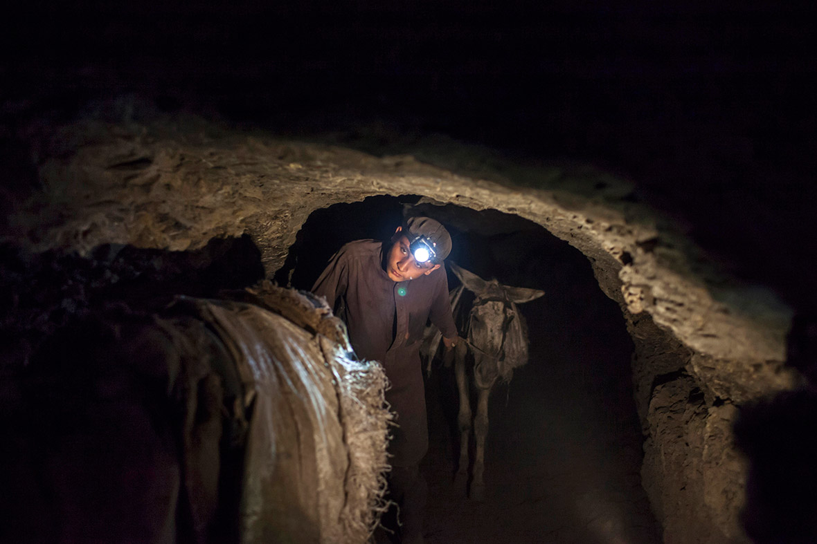 A young miner leads his team of donkeys back to the coal face underground