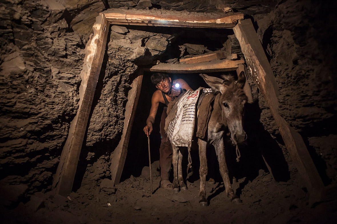 A miner and a donkey make their way through the low, narrow tunnel leading out of the coal mine