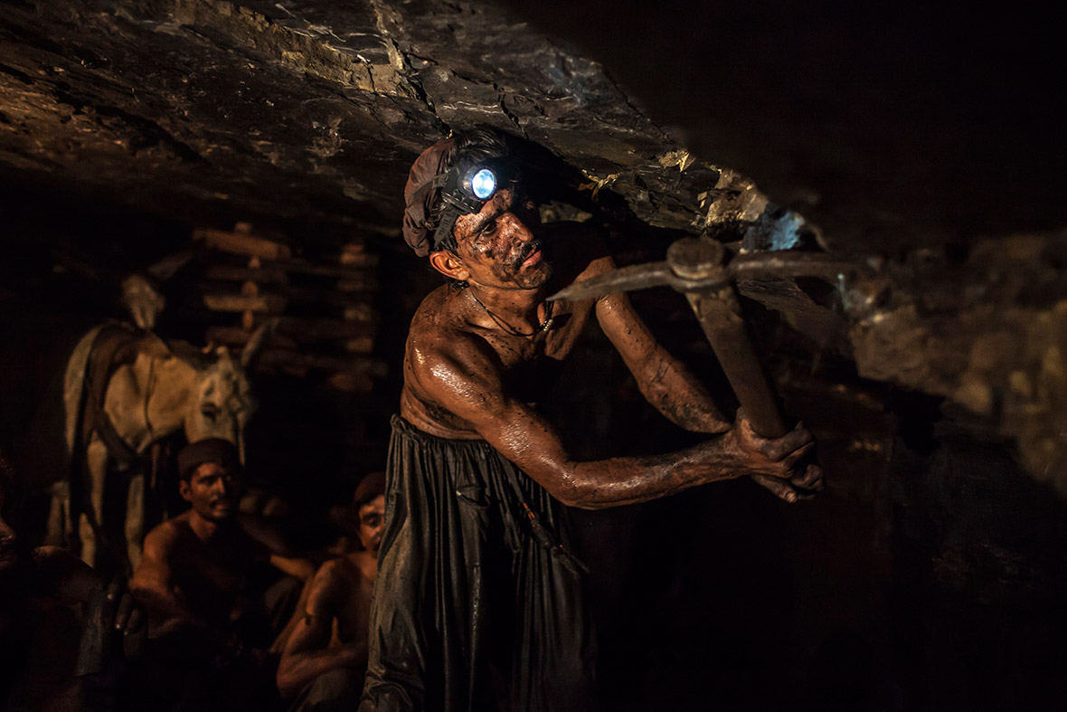 Mohammad Ismail, 25, uses a pickaxe underground in the coal mine