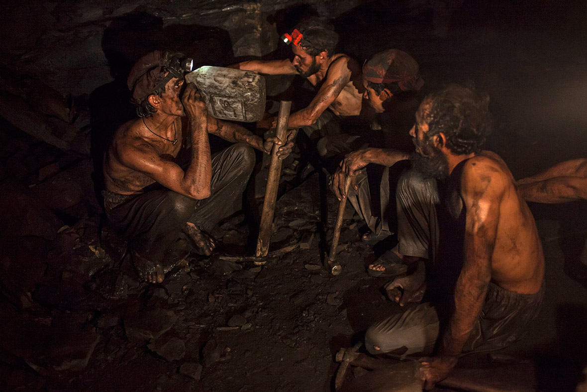 Miners take a break to drink water inside the coal mine