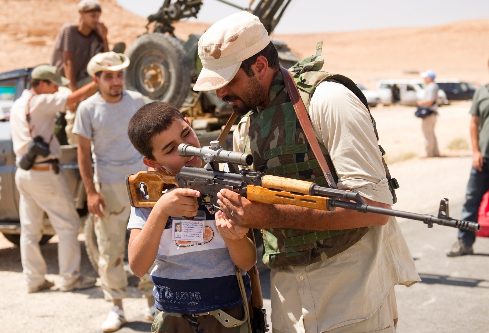 An anti-Gaddafi militant allows a boy to look through the telescopic target of his rifle near Beni Malid in 2011. (Getty)