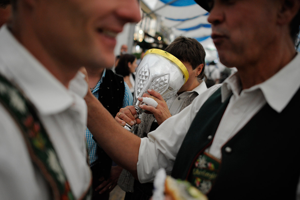 A member of the Oberammergau club drinks beer from their trophy after they won the team event.