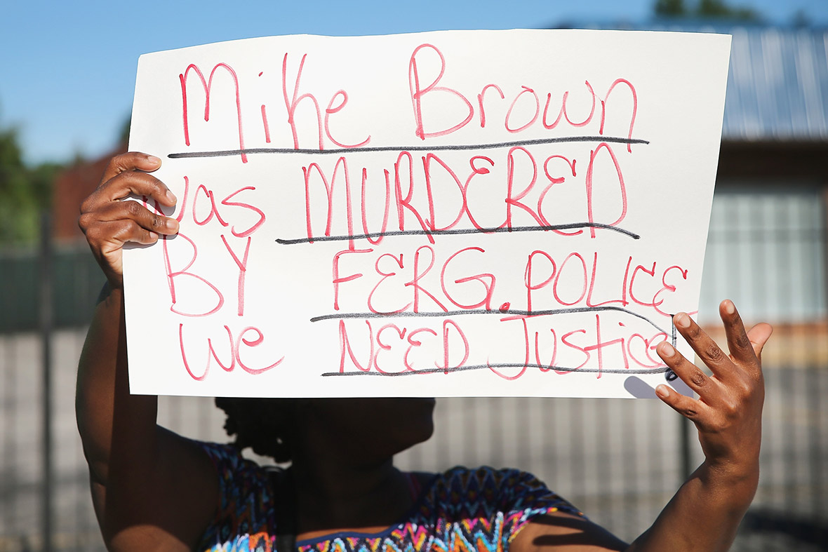 A demonstrator holds a sign claiming Mike Brown was murdered by the police