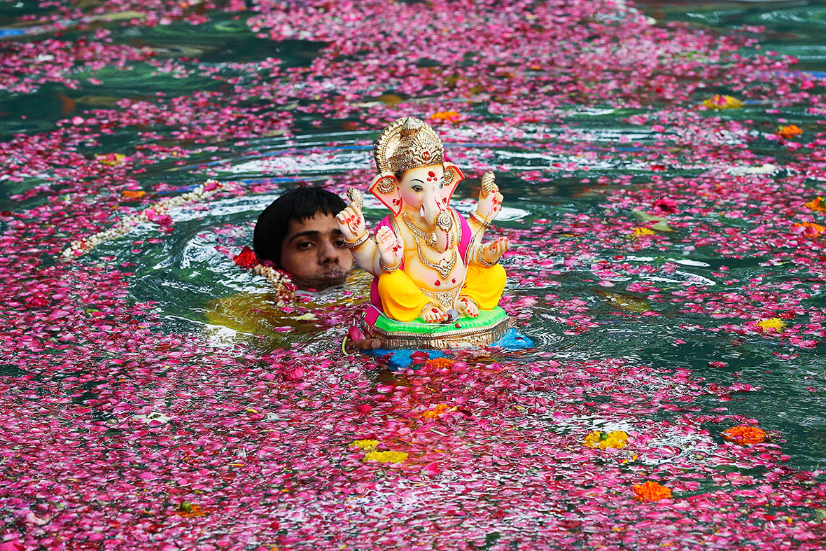 A devotee immerses an idol of the Hindu elephant god Ganesh, the deity of prosperity, in a pond during the Ganesh Chaturthi festival in Mumbai