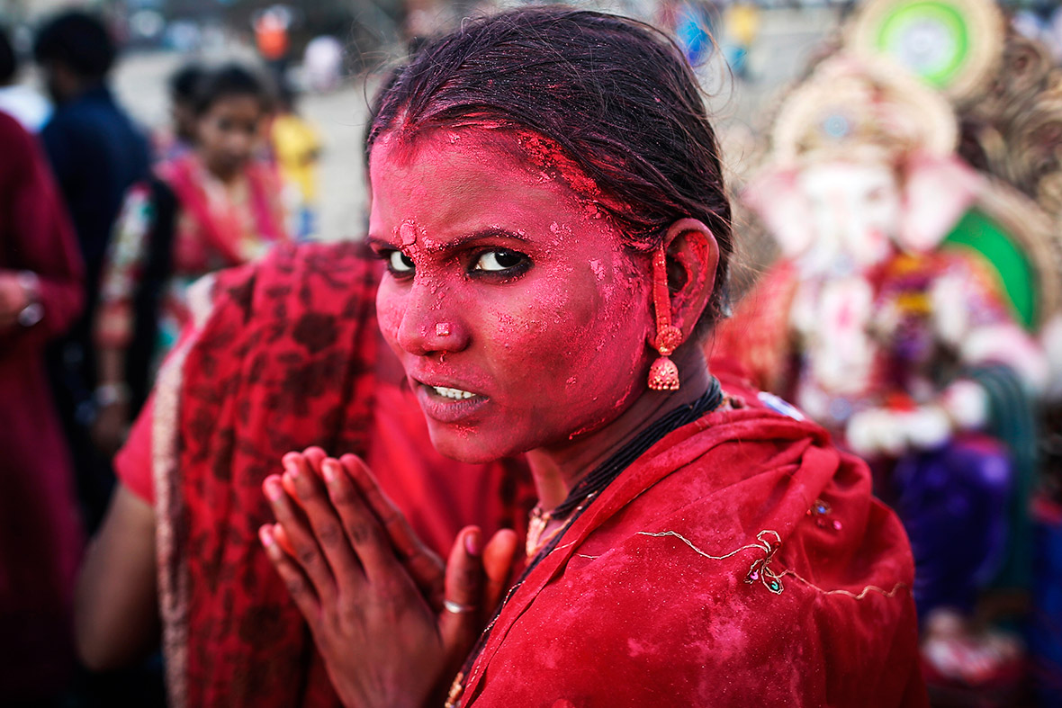 A devotee daubed in coloured powder takes part in the Ganesh Chaturthi festival in Mumbai