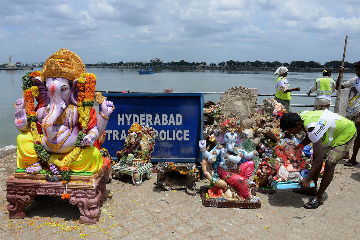 Indian Hyderabad Metropolitan Development Authority workers remove statues of Ganesh from the Hussain Sagar Lake after their immersion