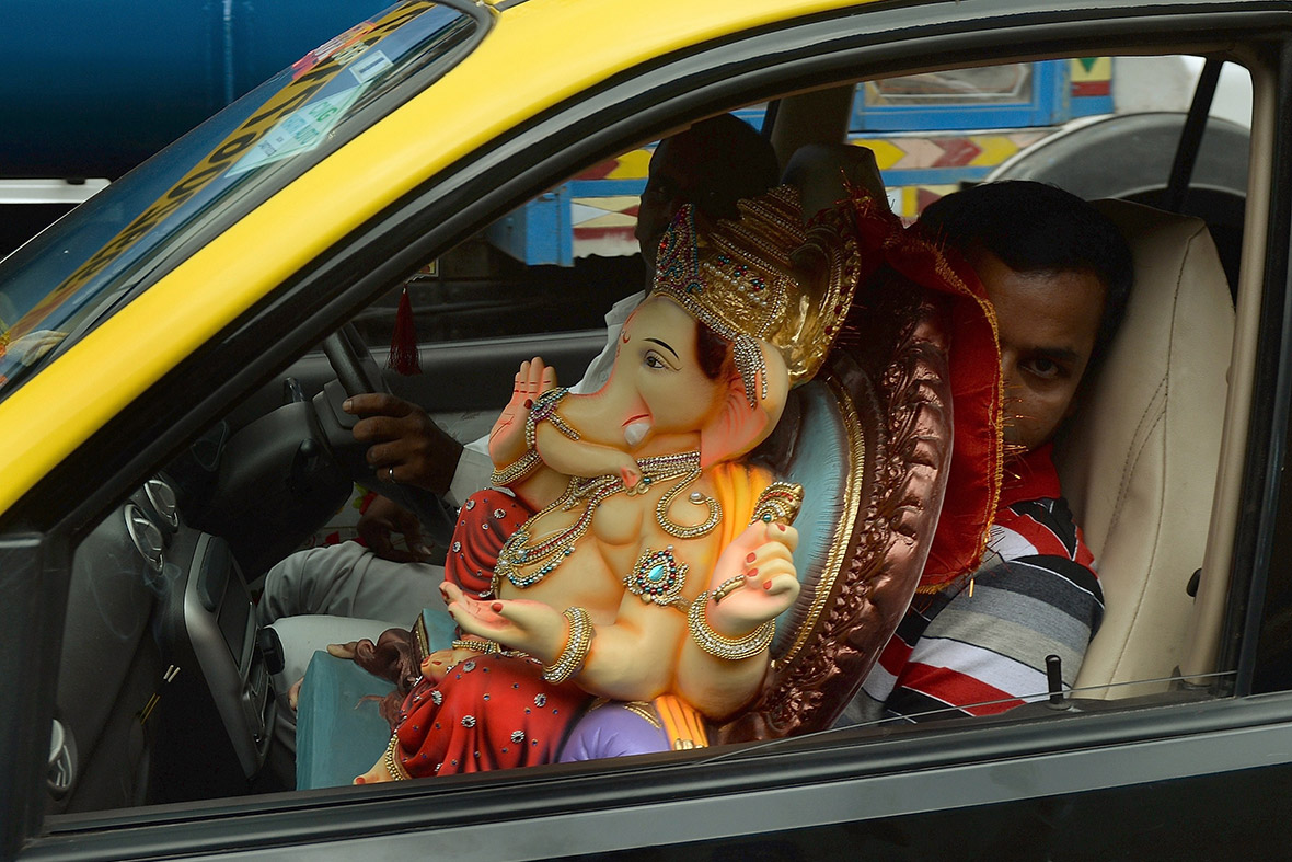 A man transports an idol of the elephant-headed Hindu god in a taxi cab in Mumbai