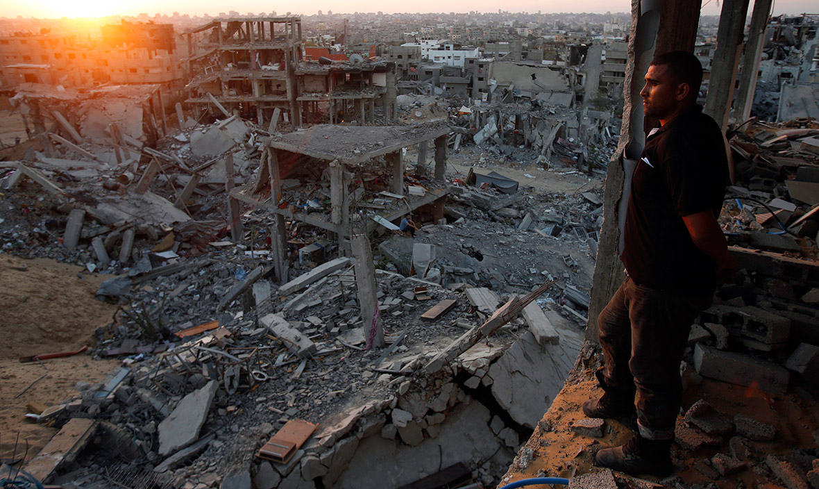 A Palestinian man looks out from his heavily damaged house at neighbouring houses reduced to rubble after the Israeli offensive in the east of Gaza City gaza rubble