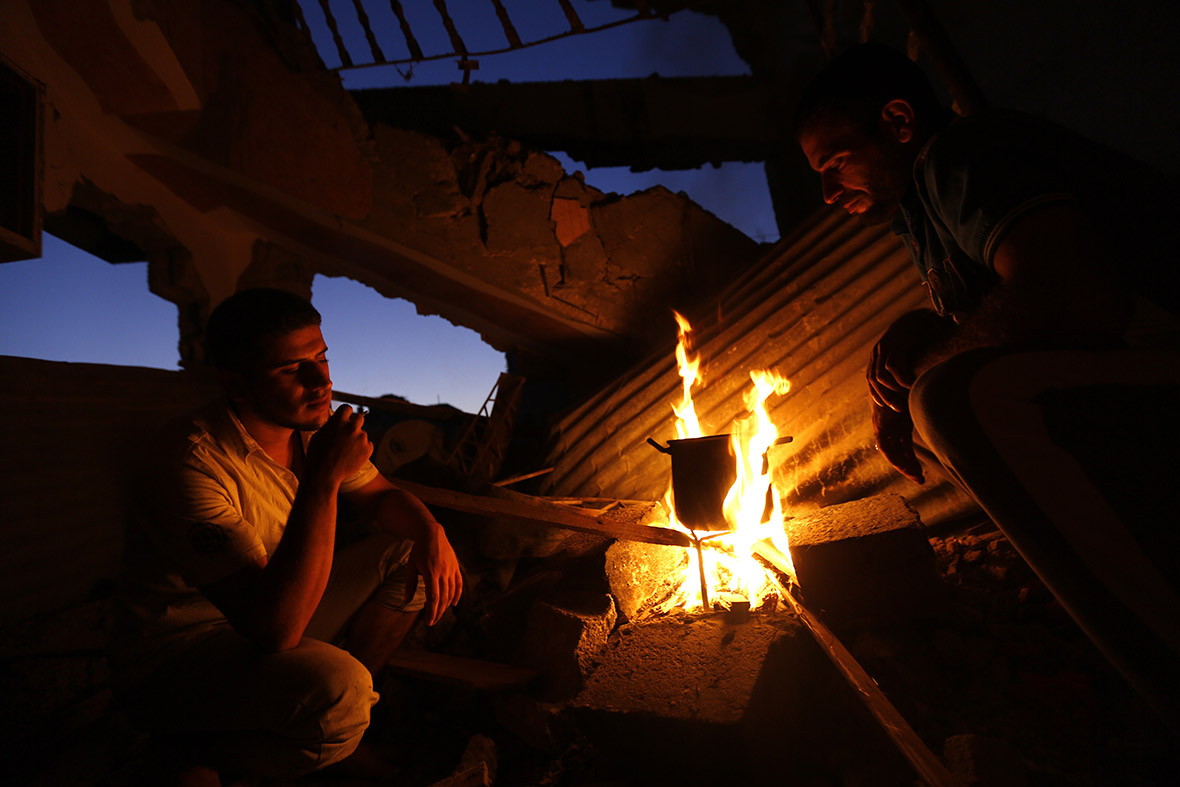 Palestinian men boil water amid the rubble of destroyed houses in the Shejaiya neighbourhood of Gaza City gaza rubble