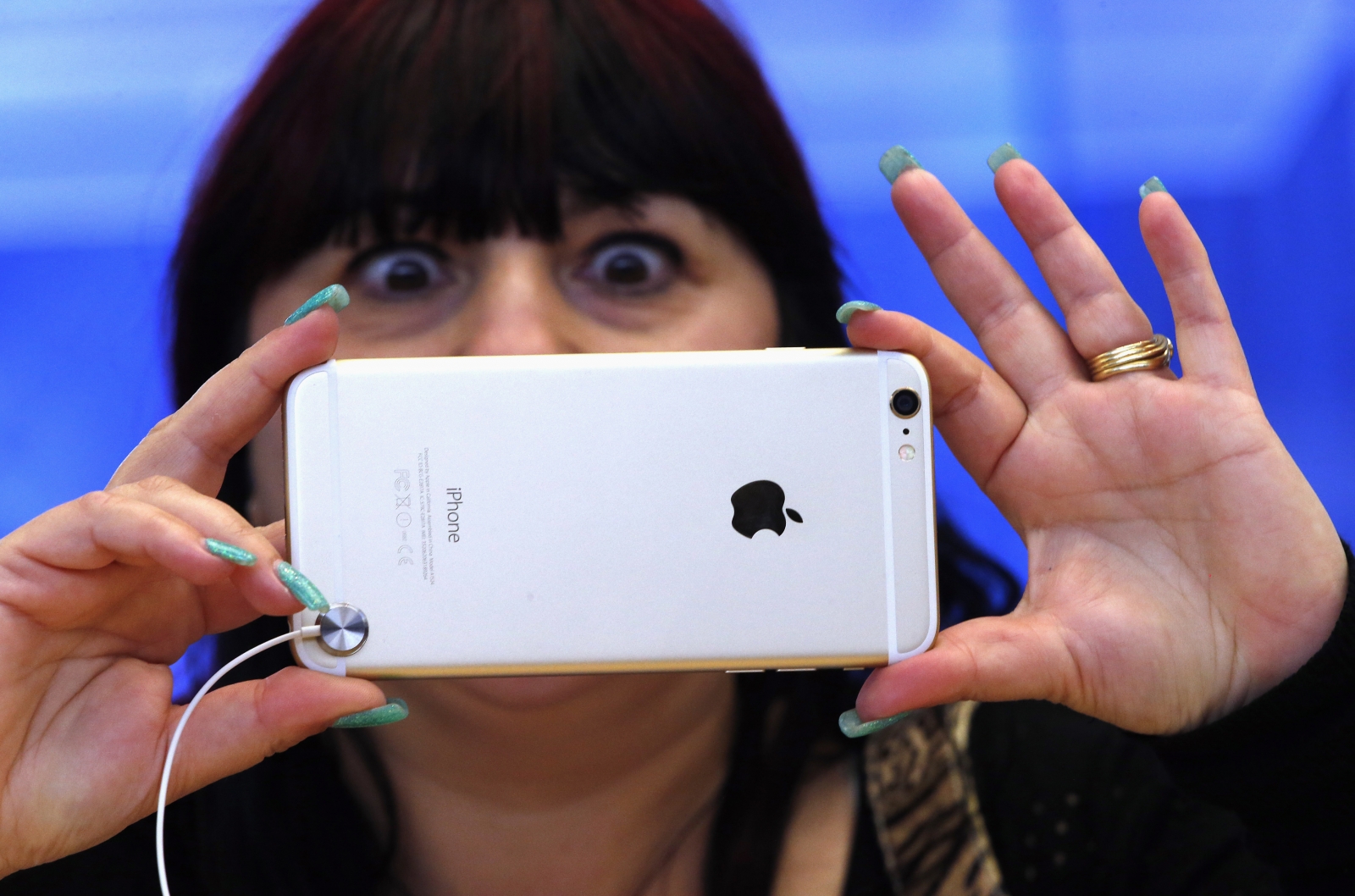 A woman reacts as she takes a photograph on an iPhone 6 Plus after it went on sale at the Apple store in Sydney. iphone 6
