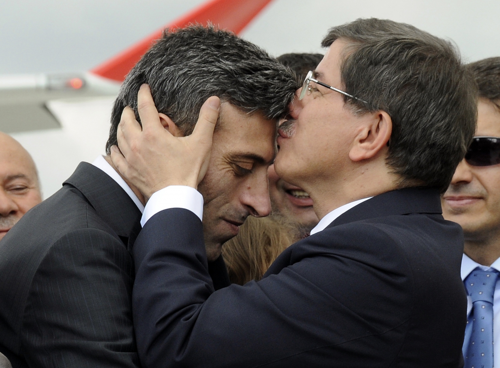 Turkish Prime Minister Ahmet Davutoglu (R) kisses Turkish Consul General of Mosul Ozturk Yilmaz on the forehead