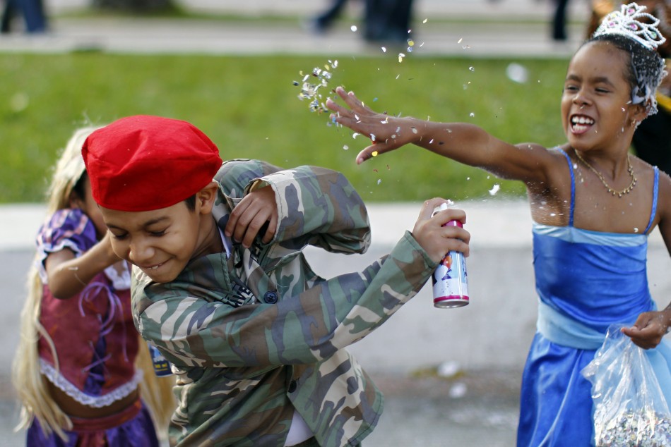 A boy wearing a uniform similar to usually worn by Venezuela's President Hugo Chavas, and two girls, play during a carnival parade in Caracas February 21, 2012. A boy wearing a uniform similar to usually worn by Venezuela's President Hugo Chavez