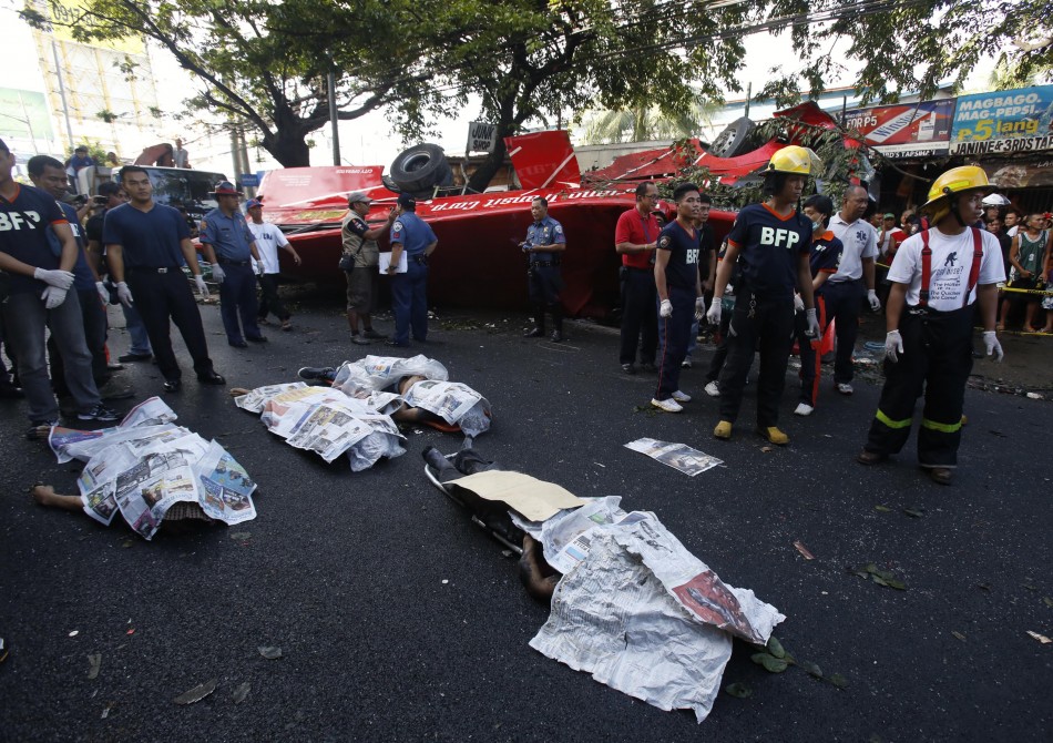 Bodies of passengers lie beside a bus after it fell off an elevated expressway and crashed into a van below in Taguig city, south of Manila