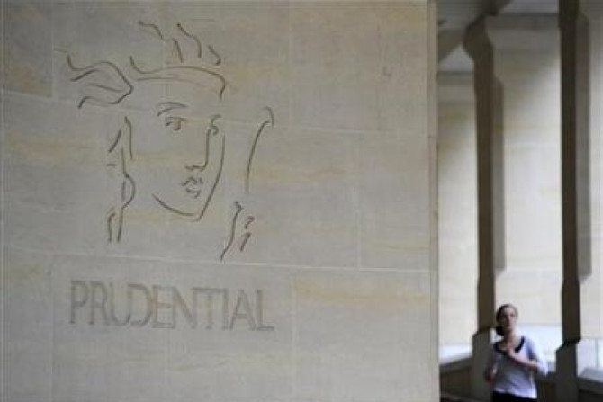A woman passes the Prudential offices in central London