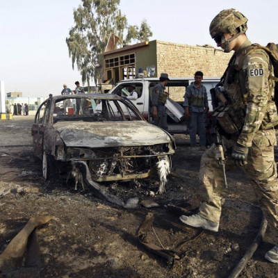 A U.S. soldier walks at the site of suicide attack in Jalalabad