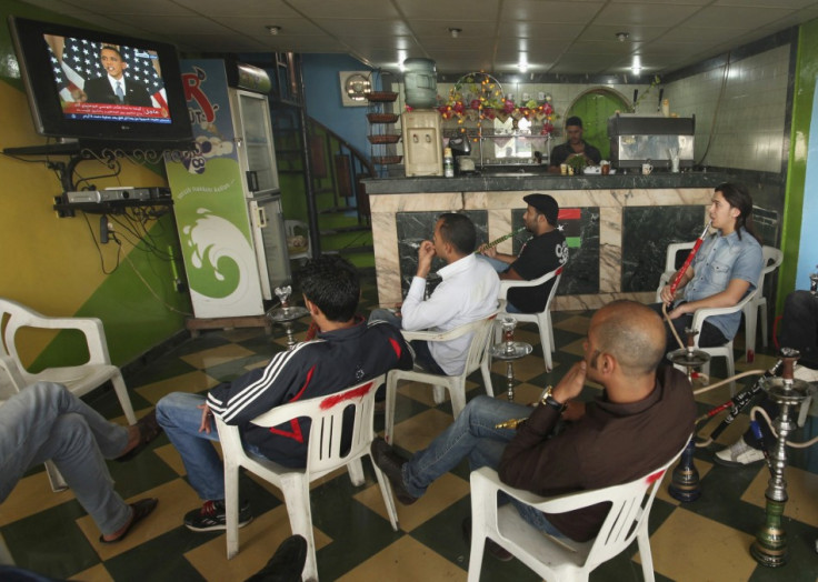 Libyans watch a television broadcast of a speech by U.S. President Barack Obama in U.S., at a shop in Benghazi