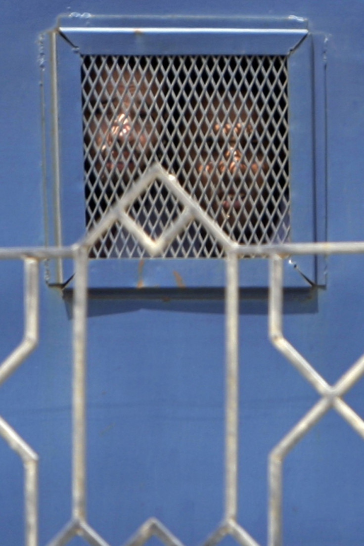 Unidentified suspects look on from inside a vehicle as they they leave the Emergency State Security Court in New Cairo