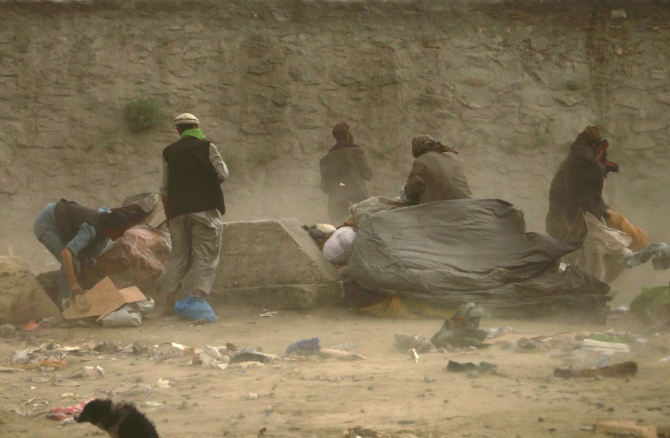 Afghan men take cover during a dusty day in Kabul