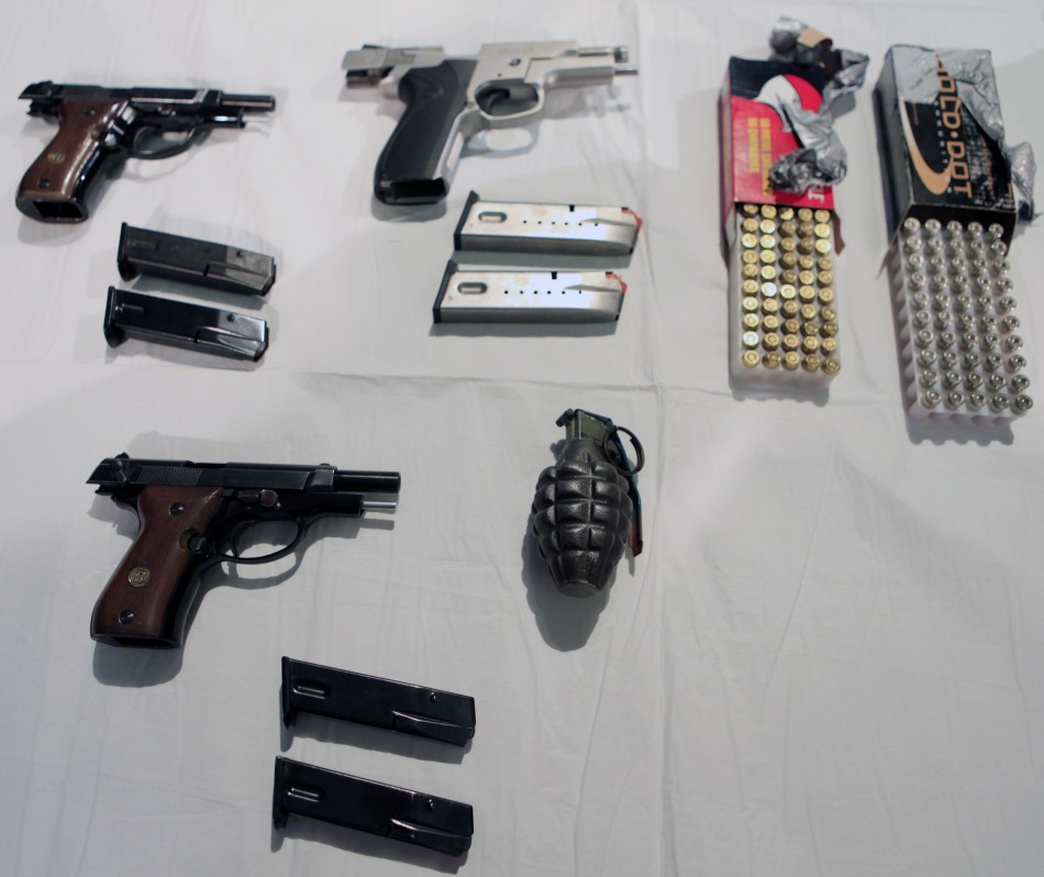 A group of weapons, ammunition and a hand grenade are displayed at a news conference at City Hall in New York