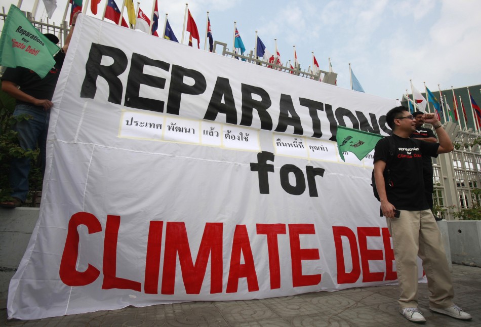 Activists from JSAPMDD shout slogan near a banner during a demonstration in front of the United Nations building in