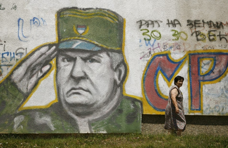 A woman walks past graffiti of Bosnian Serb fugitive general Ratko Mladic in Belgrade