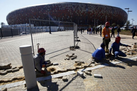 Workers pave the ground outside the Soccer City stadium in Soweto, Johannesburg