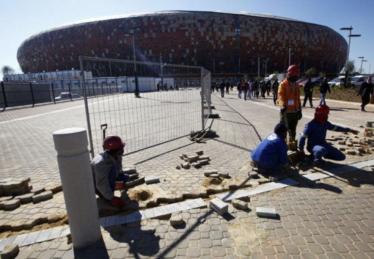 Workers pave the ground outside the Soccer City stadium in Soweto, Johannesburg
