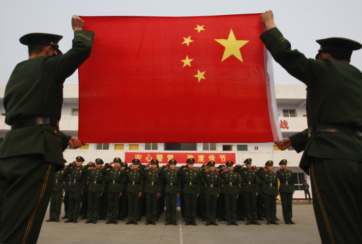 Paramilitary police recruits take an oath in front of a Chinese national flag during a military rank conferral ceremony at a military base in Suining
