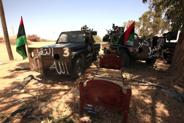 Pickups belonging to Libyan rebel fighters are seen under trees while they are on standby at Misrata's eastern front line