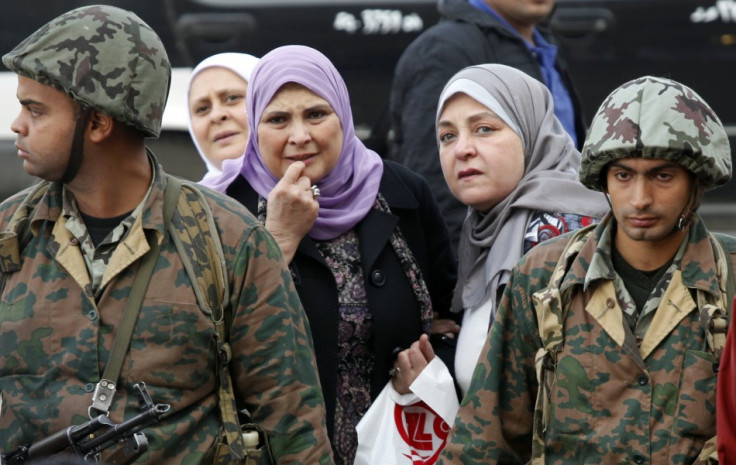Egyptian soldiers stand in front of women at Tahrir Square in Cairo